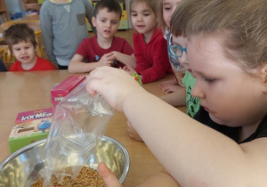 Dzieci przygotowują ziarno do ciasteczek dla ptaków